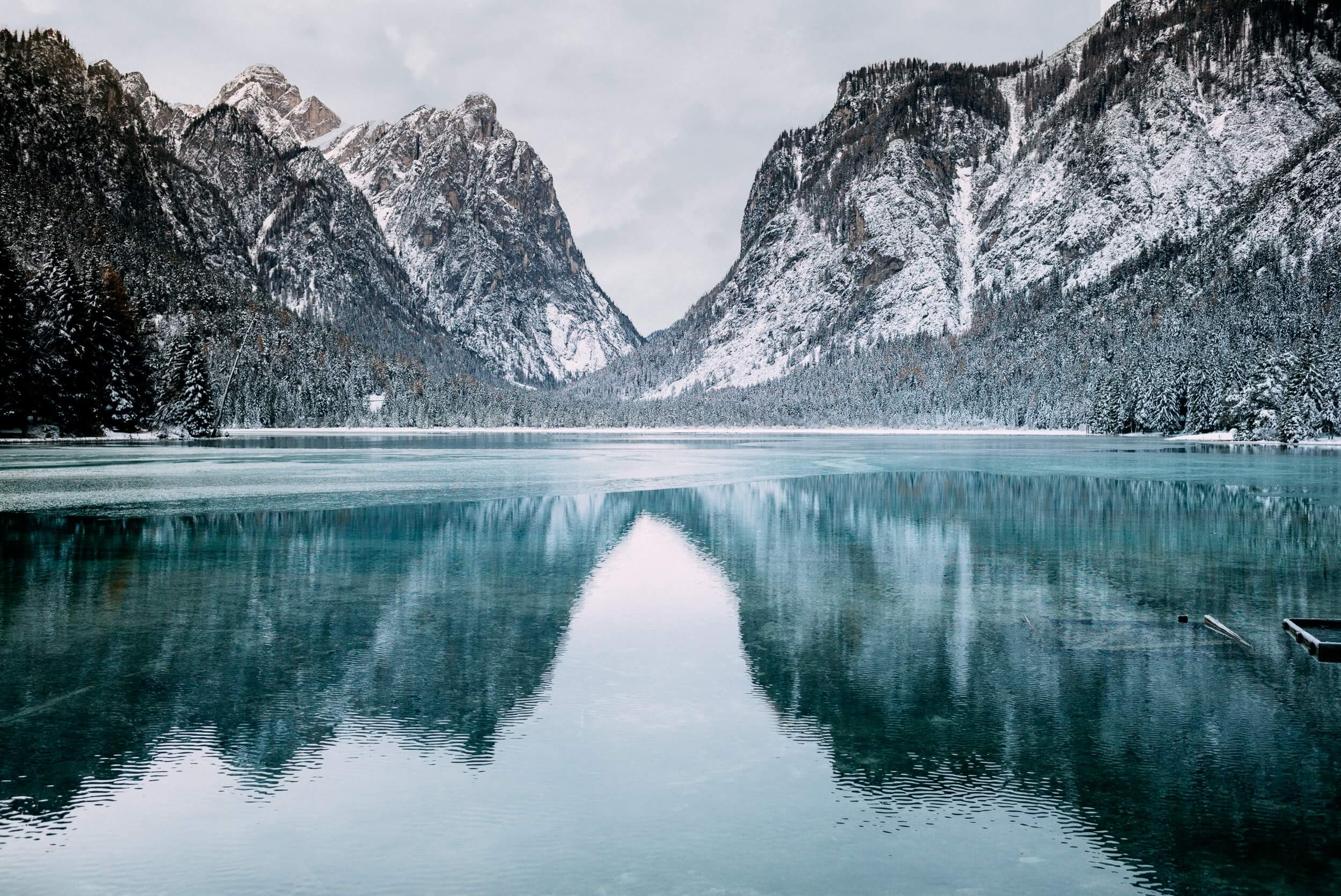 a calm lake surrounded by snow-top mountains